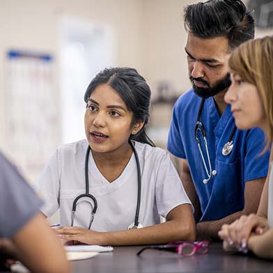 A medical professional explaining something to her team A medical professional explaining something to her team