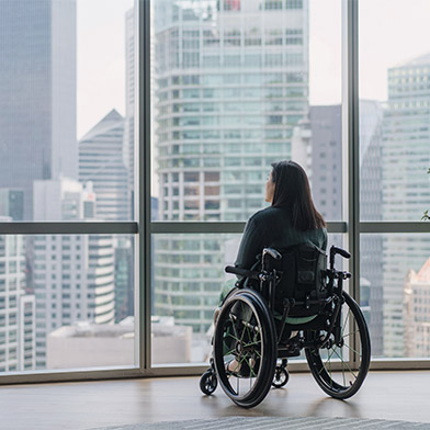Disabled woman in wheelchair enjoying the view from her high rise apartment Disabled woman in wheelchair enjoying the view from her high rise apartment